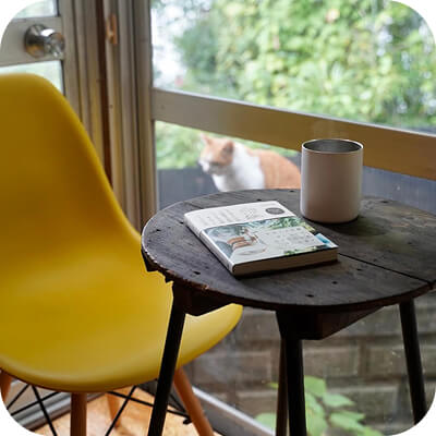 机の上に置かれたコーヒーと黄色い椅子